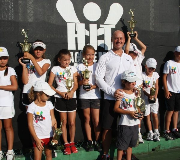 Tennis School player with trophies and coach